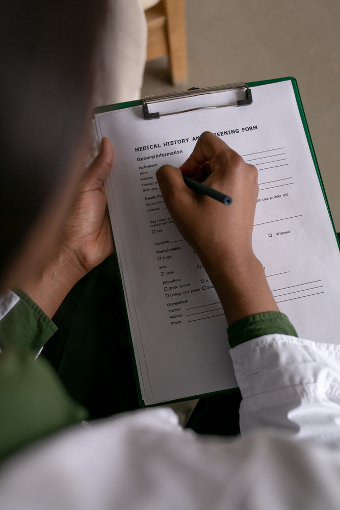 Green Medicine Doctor Writing on Medical History Sheet